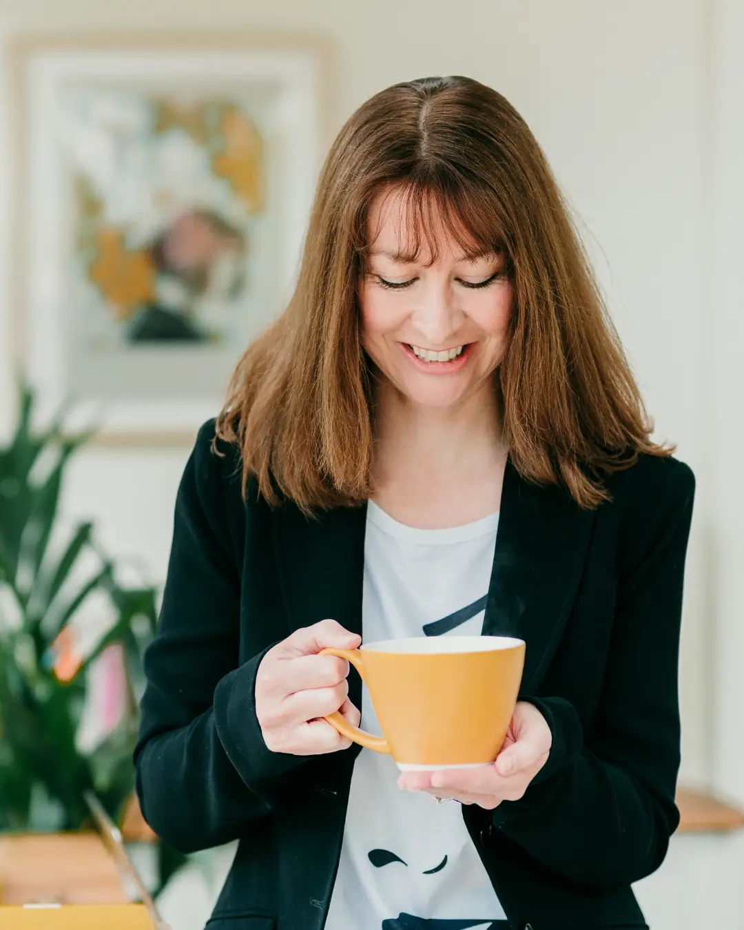 Woman wearing a jacket and holding a coffee cup